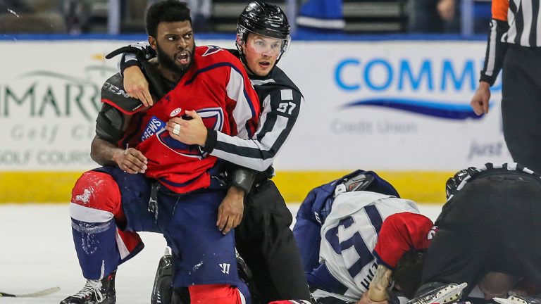 After an on-ice fight, South Carolina Stingrays defenceman Jordan Subban (5), left, is held by linesman Shane Gustafson while Jacksonville Icemen defenseman Jacob Panetta (15) is face-down on the ice engaged with another player during overtime of an ECHL hockey game in Jacksonville, Fla., Saturday, Jan. 22, 2022. (Gary McCullough/AP)