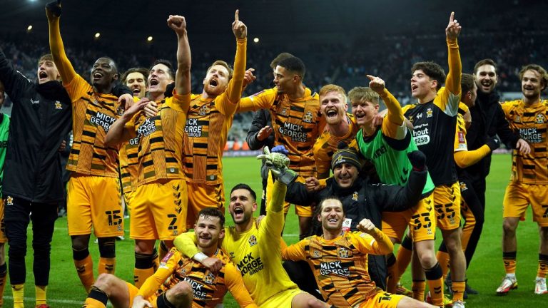 Cambridge United players celebrate victory after the final whistle of the English FA Cup third round soccer match between Newcastle United and Cambridge United at St. James' Park, Newcastle upon Tyne, England, Saturday Jan. 8, 2022. (Owen Humphreys/PA via AP)