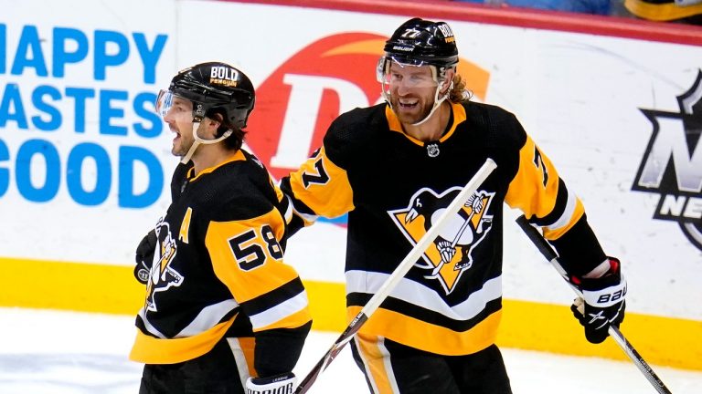 Pittsburgh Penguins' Kris Letang (58) celebrates with Jeff Carter after scoring during the third period of an NHL hockey game against the Arizona Coyotes in Pittsburgh, Tuesday, Jan. 25, 2022. It was Letang's second goal of the 6-3 Penguins win. (Gene J. Puskar/AP)