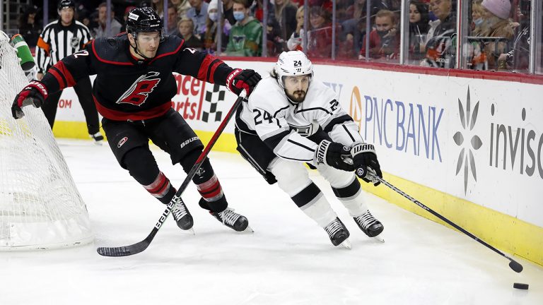 Los Angeles Kings' Phillip Danault (24) tries to regain control of the puck in front of Carolina Hurricanes' Brett Pesce (22) during the first period of an NHL hockey game. (Karl B DeBlaker/AP)