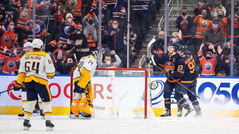 Nashville Predators' goalie Juuse Saros (74) looks on as Edmonton Oilers' Connor McDavid (97) and Ryan Nugent-Hopkins (93) celebrate a goal during first period NHL action. (Jason Franson/CP)