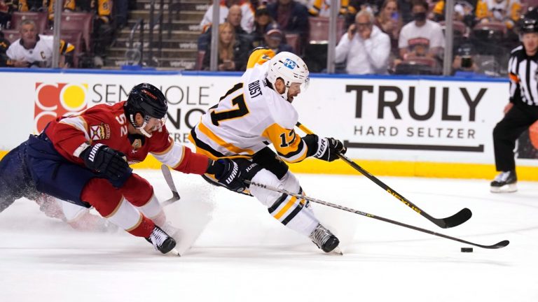 Pittsburgh Penguins right wing Bryan Rust (17) skates with the puck as Florida Panthers defenceman MacKenzie Weegar (52) defends during the first period of an NHL hockey game Thursday, Oct. 14, 2021, in Sunrise, Fla. (Lynne Sladky/AP)