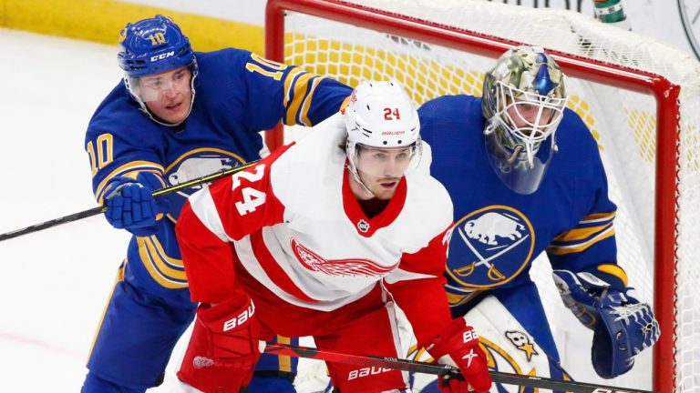 Buffalo Sabres defenceman Henri Jokiharju (10) and Detroit Red Wings centre Pius Suter (24) battle for position in front of Buffalo Sabres goaltender Aaron Dell (80) during the second period of an NHL hockey game, Monday, Jan. 17, 2022, in Buffalo, N.Y. (Jeffrey T. Barnes/AP)