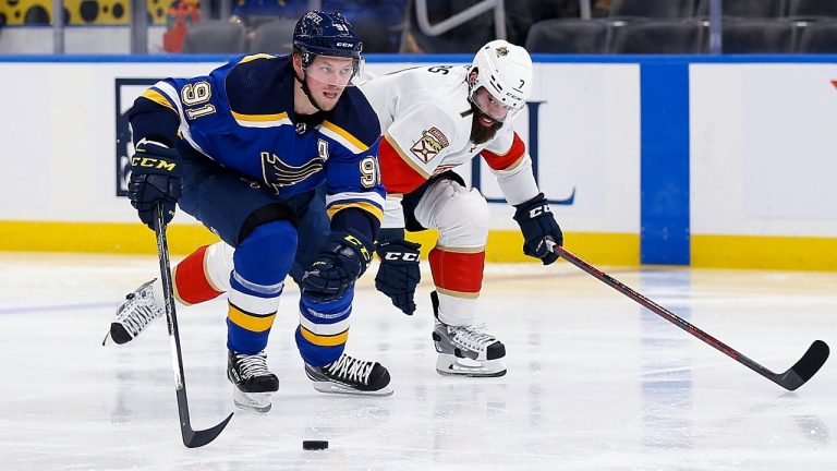 St. Louis Blues' Vladimir Tarasenko (91) drives the puck down ice while under pressure from Florida Panthers' Radko Gudas (7) during the second period of an NHL hockey game Tuesday, Dec. 7, 2021, in St. Louis. (Scott Kane/AP)