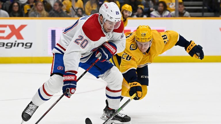 Nashville Predators right wing Eeli Tolvanen (28) reaches for the puck in front of Montreal Canadiens defenseman Chris Wideman (20) during the second period of an NHL hockey game Saturday, Dec. 4, 2021, in Nashville, Tenn. (Mark Zaleski/AP) 