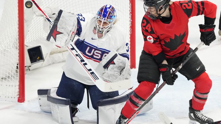 Team United States goalkeeper Alex Cavallini (33) makes a save as Team Canada forward Natalie Spooner (24) looks on during first period women's hockey gold medal game action at the 2022 Winter Olympics in Beijing on Thursday, Feb. 17, 2022. THE CANADIAN PRESS/Ryan Remiorz