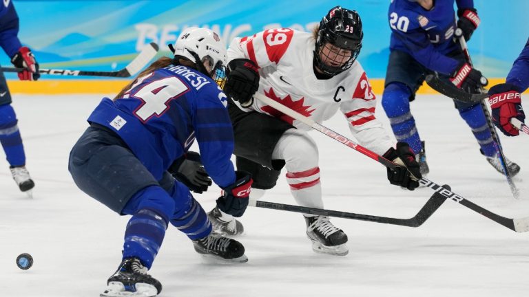 Canada's Marie-Philip Poulin (29) and United States' Dani Cameranesi (24) battle for the puck during a preliminary round women's hockey game at the 2022 Winter Olympics, Tuesday, Feb. 8, 2022, in Beijing. (Petr David Josek/AP)