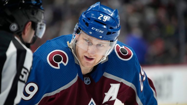 Colorado Avalanche center Nathan MacKinnon, right, chats with linesman Mark Wheler whie waiting for a face off against the Anaheim Ducks in the third period of an NHL hockey game Sunday, Jan. 2, 2022, in Denver. The Avalanche won 4-2. (David Zalubowski/AP)