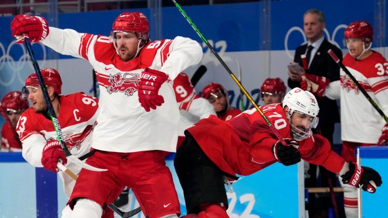 Denmark's Mathias Bau, left, and Switzerland's Denis Hollenstein (70) collide during a preliminary round men's hockey game at the 2022 Winter Olympics, Saturday, Feb. 12, 2022, in Beijing. (Petr David Josek/AP Photo)