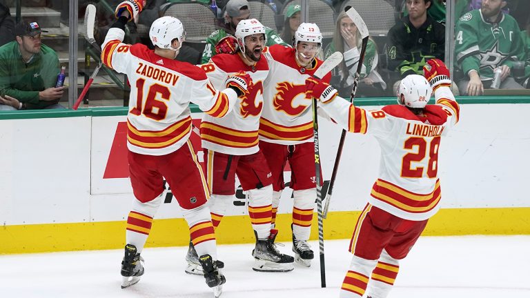 Calgary Flames' Nikita Zadorov (16), Oliver Kylington (58), Johnny Gaudreau (13) and Elias Lindholm (28) celebrate a goal scored by Kylington in the third period of an NHL hockey game against the Dallas Stars. (AP)