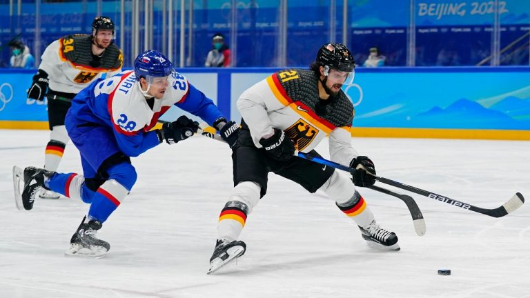 Slovakia's Martin Gernat (28) pressures Germany's Nicolas Krammer (21) during a men's qualification round hockey game at the 2022 Winter Olympics, Tuesday, Feb. 15, 2022, in Beijing. (Matt Slocum/AP Photo)