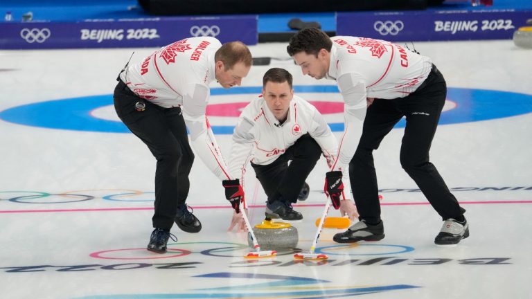 Canada skip Brad Gushue (centre) watches his shot as Geoff Walker (left) and Brett Gallant sweep during men's curling action against Denmark at the Beijing Winter Olympics in Beijing, China, on Wednesday, Feb. 9, 2022. (Ryan Remiorz/THE CANADIAN PRESS)