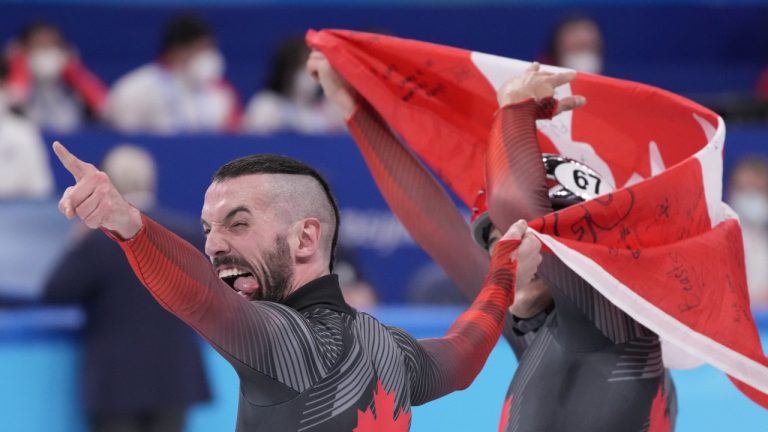 Charles Hamelin (6) of Canada reacts with teammate Jordan Pierre Gilles after winning gold in the men's 5,000-metre short-track speedskating relay final at the Beijing Winter Olympics in Beijing, China, on Wednesday, Feb. 16, 2022. (Paul Chiasson/THE CANADIAN PRESS)