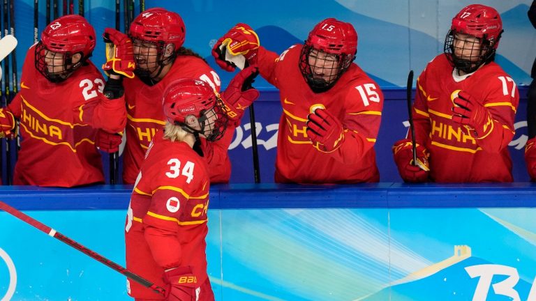 China's Le Mi (34) is congratulated after scoring a shootout goal against Japan during a preliminary round women's hockey game at the 2022 Winter Olympics, Sunday, Feb. 6, 2022, in Beijing. The goal gave China a 2-1 win. (Petr David Josek/AP Photo)