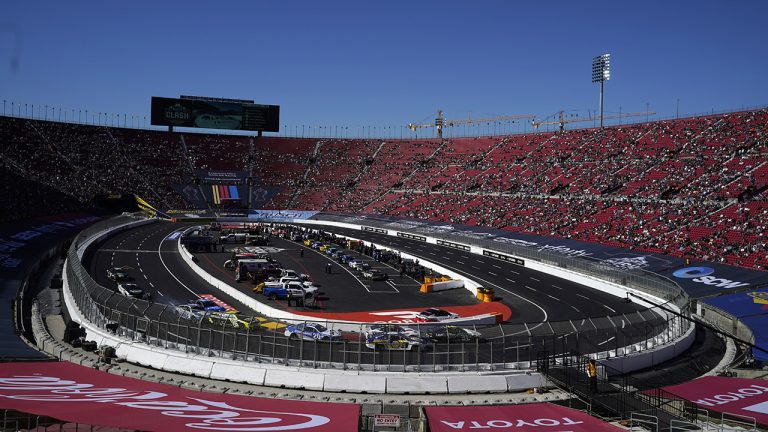 Competitors make a turn during a heat race ahead of a NASCAR exhibition auto race at Los Angeles Memorial Coliseum, Sunday, Feb. 6, 2022, in Los Angeles. (AP Photo/Marcio Jose Sanchez)