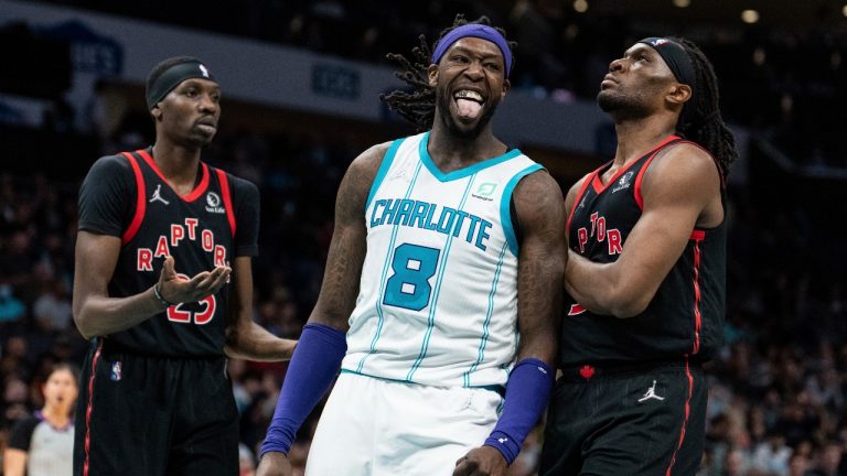 Charlotte Hornets centre Montrezl Harrell (8) reacts after making a shot while guarded by Toronto Raptors forwards Chris Boucher (25) and Precious Achiuwa (5) during the first half of an NBA basketball game in Charlotte, N.C., Friday, Feb. 25, 2022. (Jacob Kupferman/AP Photo)