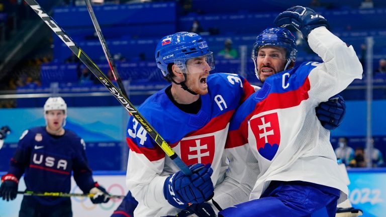 Slovakia's Marek Hrivikl, right, is hugged by Peter Cehlarik (34) after Hrivikl scored a goal against the United States during a men's quarterfinal hockey game at the 2022 Winter Olympics, Wednesday, Feb. 16, 2022, in Beijing. (Matt Slocum/AP Photo)