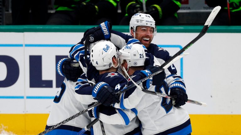 The Winnipeg Jets, including defenceman Neal Pionk (4), centre Paul Stastny (25), and right wing Blake Wheeler (26), celebrate a goal against the Dallas Stars in the final minute of regulation play in an NHL hockey game Friday, Feb 11, 2022, in Dallas. (Richard W. Rodriguez/AP Photo)