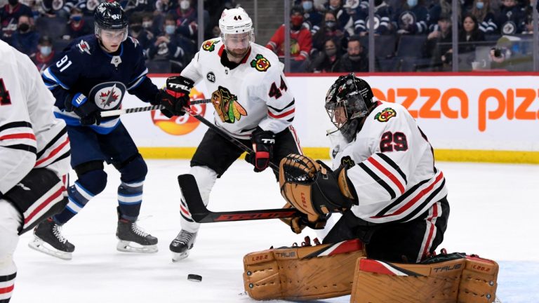 Chicago Blackhawks goaltender Marc-Andre Fleury (29) makes a save as Calvin de Haan (44) defends against Cole Perfetti (91) during the second period of NHL action in Winnipeg, Monday, Feb. 14, 2022. (Fred Greenslade/CP)