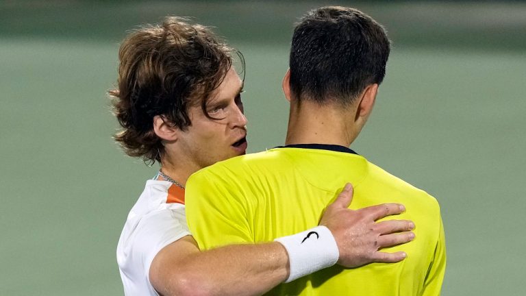 Russia's Andrey Rublev, left, comforts Poland's Hubert Hurkacz, after he beats him during a semifinal match of the Dubai Duty Free Tennis Championship in Dubai. (Kamran Jebreili/AP)