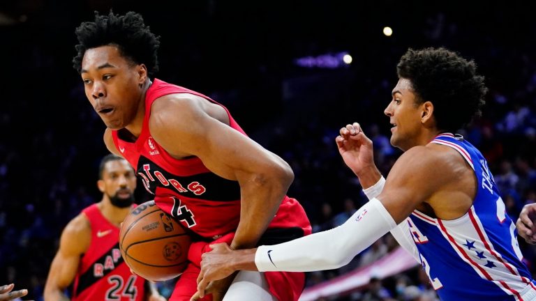 Toronto Raptors' Scottie Barnes, left, tries to hang onto the ball against Philadelphia 76ers' Matisse Thybulle during the first half of an NBA basketball game, Sunday, March 20, 2022, in Philadelphia. (Matt Slocum/AP Photo)