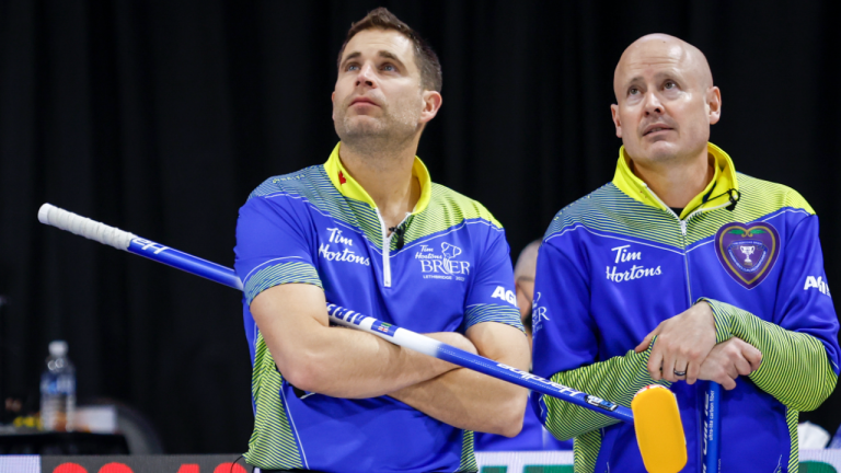 Team Alberta second John Morris, left, and skip Kevin Koe look to the scoreboard while playing Team Ontario at the Tim Hortons Brier in Lethbridge, Alta., Sunday, March 6, 2022. (CP)