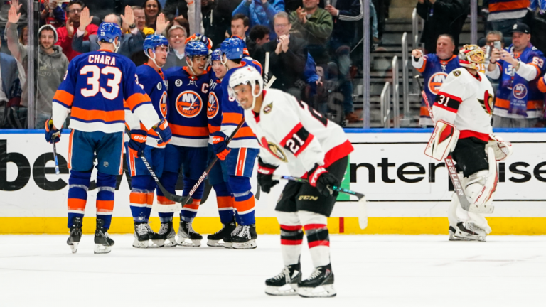 The New York Islanders celebrate a goal by Anders Lee as Ottawa Senators' Mathieu Joseph (21) and Anton Forsberg (31) skate away during the third period of an NHL hockey game Tuesday, March 22, 2022, in Elmont, N.Y. The Islanders won 3-0. (AP)