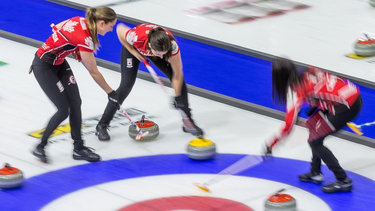 From left, Canada lead Briane Meilleur, second Shannon Birchard, and skip Kerri Einarson sweep in front of a stone against Sweden at the Women's World Curling Championship in Prince George, B.C., on Wednesday, March 23, 2022. (James Doyle/CP)