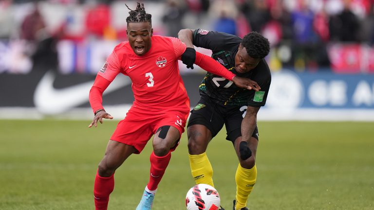 Canada's Sam Adekugbe and Jamaica's Javain Brown battle for ther ball during first half CONCACAF World Cup soccer qualifying action in Toronto on Sunday, March 27, 2022. (Nathan Denette/CP)