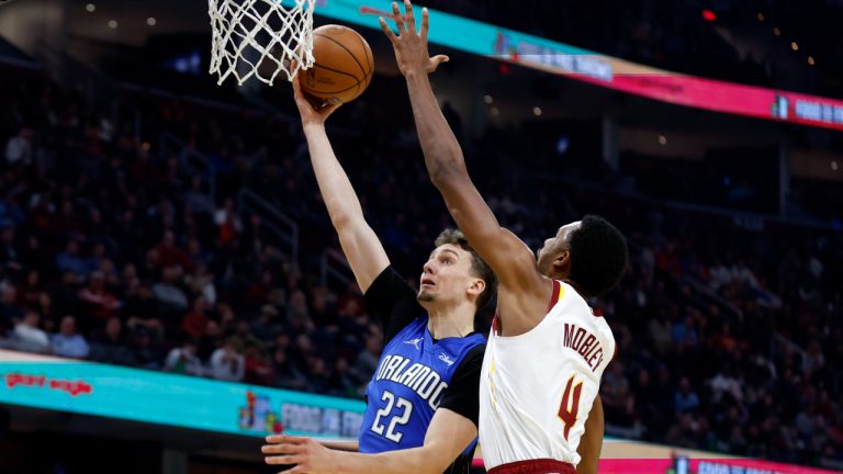 Orlando Magic's Franz Wagner (22) shoots against Cleveland Cavaliers' Evan Mobley (4) during the first half of an NBA basketball game, Monday, March 28, 2022, in Cleveland. (AP Photo/Ron Schwane)