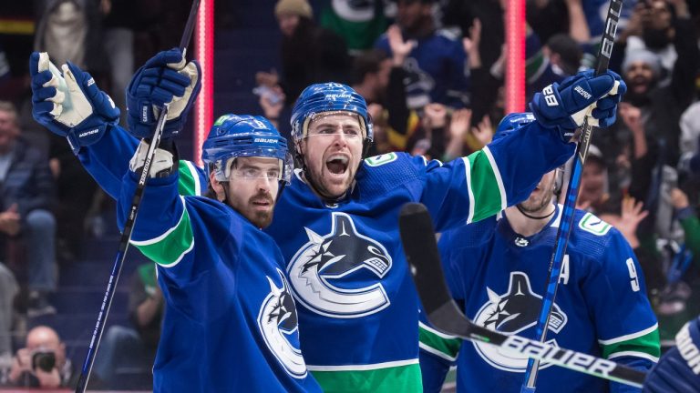 Vancouver Canucks' Tanner Pearson, centre, and Conor Garland, left, celebrate Pearson's goal against the New Jersey Devils during the second period of an NHL hockey game in Vancouver, on Tuesday, March 15, 2022. (Darryl Dyck/THE CANADIAN PRESS)