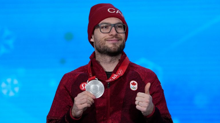 Silver medalist Laurent Dubreuil of Canada celebrates during a medal ceremony for the men's speedskating 1,000-meter at the 2022 Winter Olympics, Saturday, Feb. 19, 2022, in Beijing. (Jae C. Hong/AP)