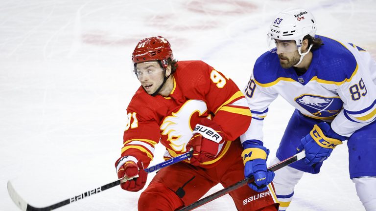 Buffalo Sabres' Alex Tuch, right, checks Calgary Flames' Calle Jarnkrok during first period NHL hockey action. (Jeff McIntosh/CP)