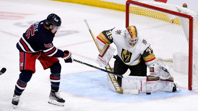 Vegas Golden Knights goaltender Laurent Brossoit (39) makes a save on Winnipeg Jets' Mark Scheifele (55) during the second period of NHL action in Winnipeg on Tuesday March 15, 2022. (THE CANADIAN PRESS/Fred Greenslade)