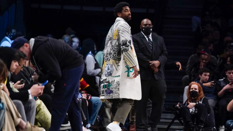 Brooklyn Nets' Kyrie Irving watches the game from the front row during the second half of the NBA basketball game between the Brooklyn Nets and the New York Knicks at the Barclays Center, Sunday, Mar. 13, 2022, in New York. The Nets defeated the Knicks 110-107. (Seth Wenig/AP)