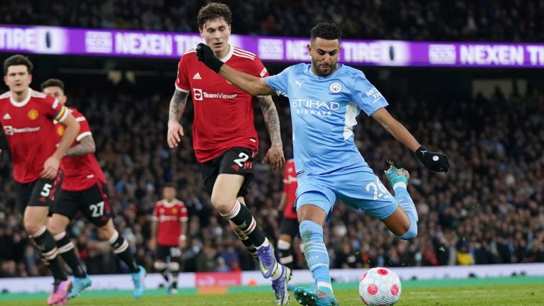 Manchester City's Riyad Mahrez, right, scores his side's fourth goal during the English Premier League soccer match between Manchester City and Manchester United, at the Etihad stadium in Manchester, England, Sunday, March 6, 2022. (Jon Super/AP)