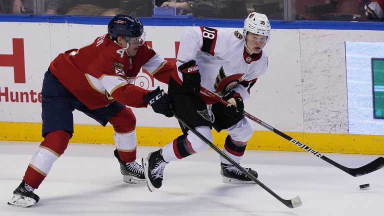 Ottawa Senators left wing Tim Stutzle (18) looks to pass the puck as Florida Panthers defenseman Olli Juolevi (4) defends during the second period at an NHL hockey game. (Marta Lavandier/AP)