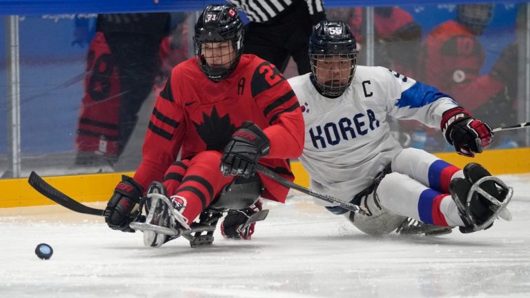 Liam Hickey of Canada battles for the puck against South Korea's Jang Jong-ho during their para ice hockey semifinal match at the 2022 Winter Paralympics, Friday, March 11, 2022, in Beijing. (Dita Alangkara/AP Photo)