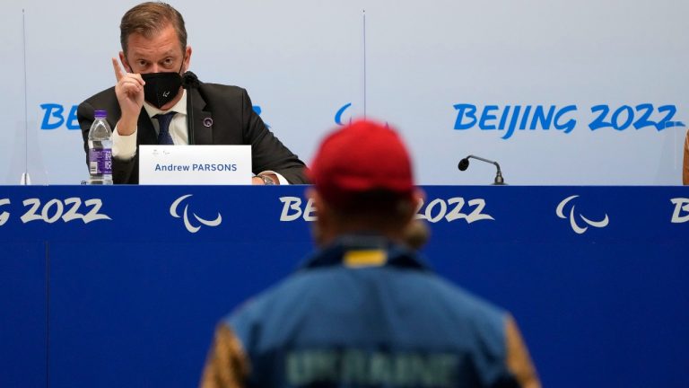 International Paralympic Committee (IPC) President Andrew Parsons speaks to a journalist from Ukraine during a press conference at the 2022 Winter Paralympics in Beijing, Wednesday, March 2, 2022. Russians and Belarusians at the Winter Paralympics in Beijing will compete as "neutral athletes" because of their countries' roles in the war against Ukraine, the International Paralympic Committee said Wednesday. (Andy Wong/AP Photo)