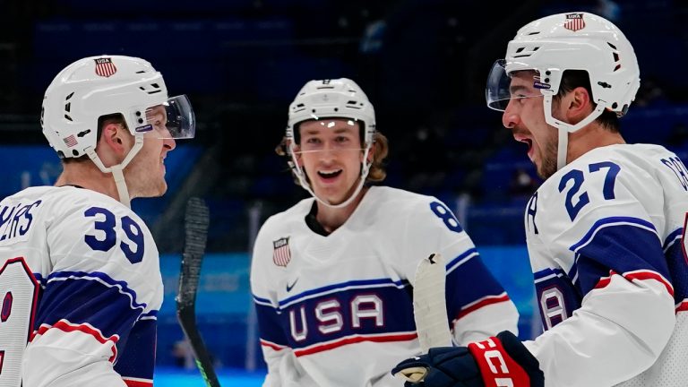 United States' Jake Sanderson (8) celebrates with Ben Meyers (39) and Noah Cates (27) after Meyers scored a goal against Canada during a preliminary round men's hockey game at the 2022 Winter Olympics, Saturday, Feb. 12, 2022, in Beijing. (Matt Slocum/AP)