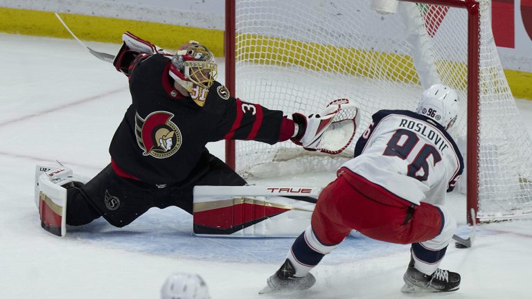 Columbus Blue Jackets centre Jack Roslovic slides the puck past Ottawa Senators goaltender Anton Forsberg to score during first period NHL action. (Adrian Wyld/CP)