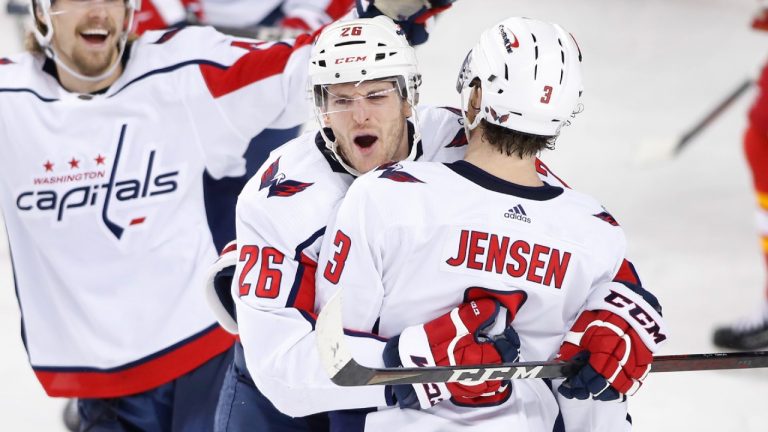 Washington Capitals' Nic Dowd, centre, celebrates with Axel Jonsson-Fjallby, left, from Sweden, and Nick Jensen his goal against the Calgary Flames during third period NHL hockey action in Calgary, Alta., Tuesday, March 8, 2022. (Larry MacDougal/CP)