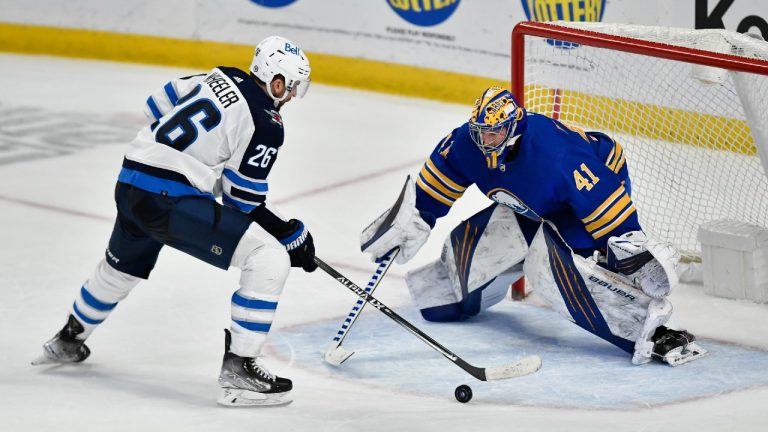 Winnipeg Jets right wing Blake Wheeler, left, works against Buffalo Sabres goalie Craig Anderson during the shootout in an NHL hockey game in Buffalo, N.Y., Wednesday, March 30, 2022. Wheeler scored. (Adrian Kraus/AP)