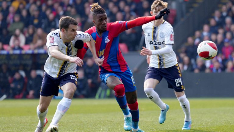 Crystal Palace's Wilfried Zaha, centre, battles with Everton's Seamus Coleman, left, during the English FA Cup quarter final soccer match between Crystal Palace and Everton at Selhurst Park, London, Sunday, March 20, 2022. (John Walton/PA via AP)