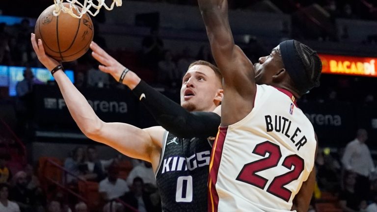 Sacramento Kings guard Donte DiVincenzo (0) drives to the basket as Miami Heat forward Jimmy Butler (22) defends during the first half of an NBA basketball game, Monday, March 28, 2022, in Miami. (Marta Lavandier/AP)