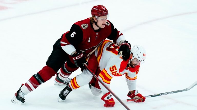 Calgary Flames defenseman Oliver Kylington (58) collides with Arizona Coyotes defenseman Jakob Chychrun (6) during the first period of an NHL hockey game Wednesday, Feb. 2, 2022, in Glendale, Ariz. (Ross D. Franklin/AP Photo)