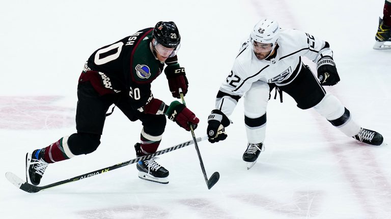 Arizona Coyotes center Riley Nash (20) passes the puck as Los Angeles Kings center Andreas Athanasiou (22) defends during the first period of an NHL hockey game Wednesday, Feb. 23, 2022, in Glendale, Ariz. (AP Photo/Ross D. Franklin)