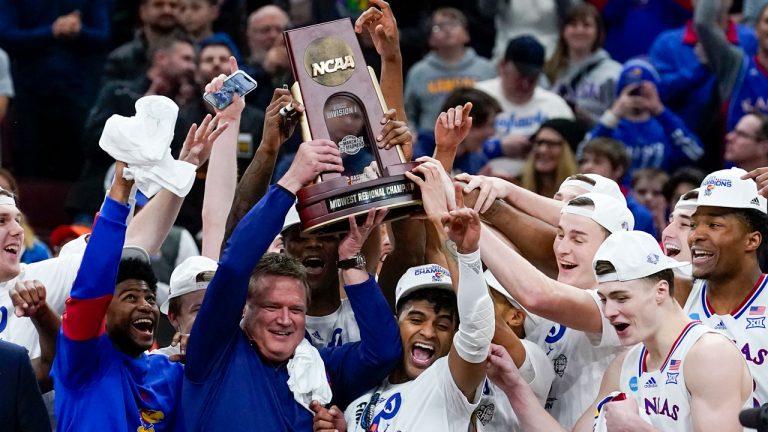 Kansas head coach Bill Self and players hold up the winning trophy after a college basketball game in the Elite 8 round of the NCAA tournament against Miami. (Charles Rex Arbogast/AP)