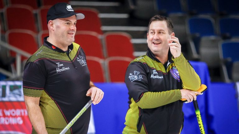 Team New Brunswick skip James Grattan, right, and third Darren Moulding share a laugh during a practice session at the Tim Hortons Brier in Lethbridge, Alta., Friday, March 4, 2022. (Jeff McIntosh/CP)