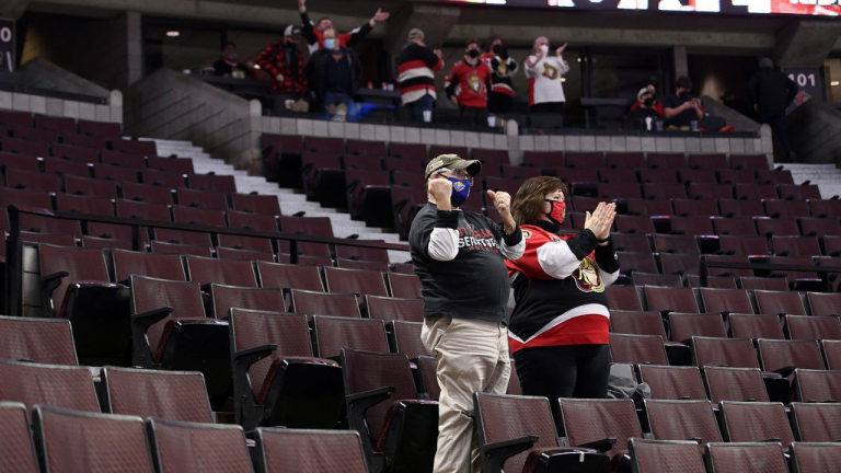 Fans celebrate the Ottawa Senators' overtime win against the Edmonton Oilers as Ontario begins to wind back public health measures put in place to curb the spread of the omicron variant of COVID-19, during third period NHL hockey action in Ottawa, on Monday, Jan. 31, 2022. (CP)